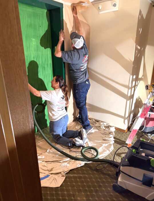 Maldonado's Painting team masking and painting an interior doorway on the job
