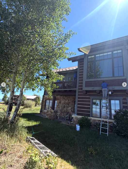 Exterior repaint in progress on a two-story mountain home