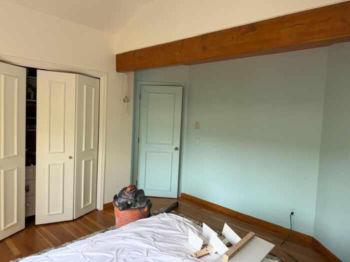 Interior bedroom with freshly painted soft blue-green accent wall